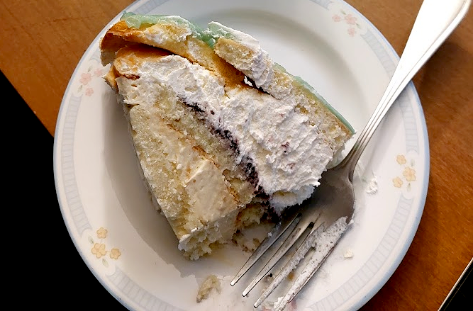A slice of Swedish princess cake showing the layers